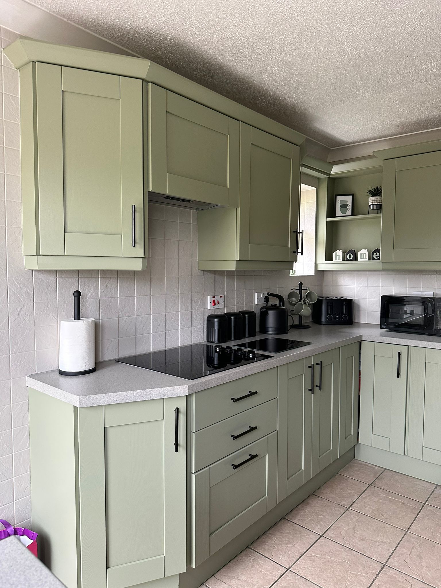 Green kitchen with black handles